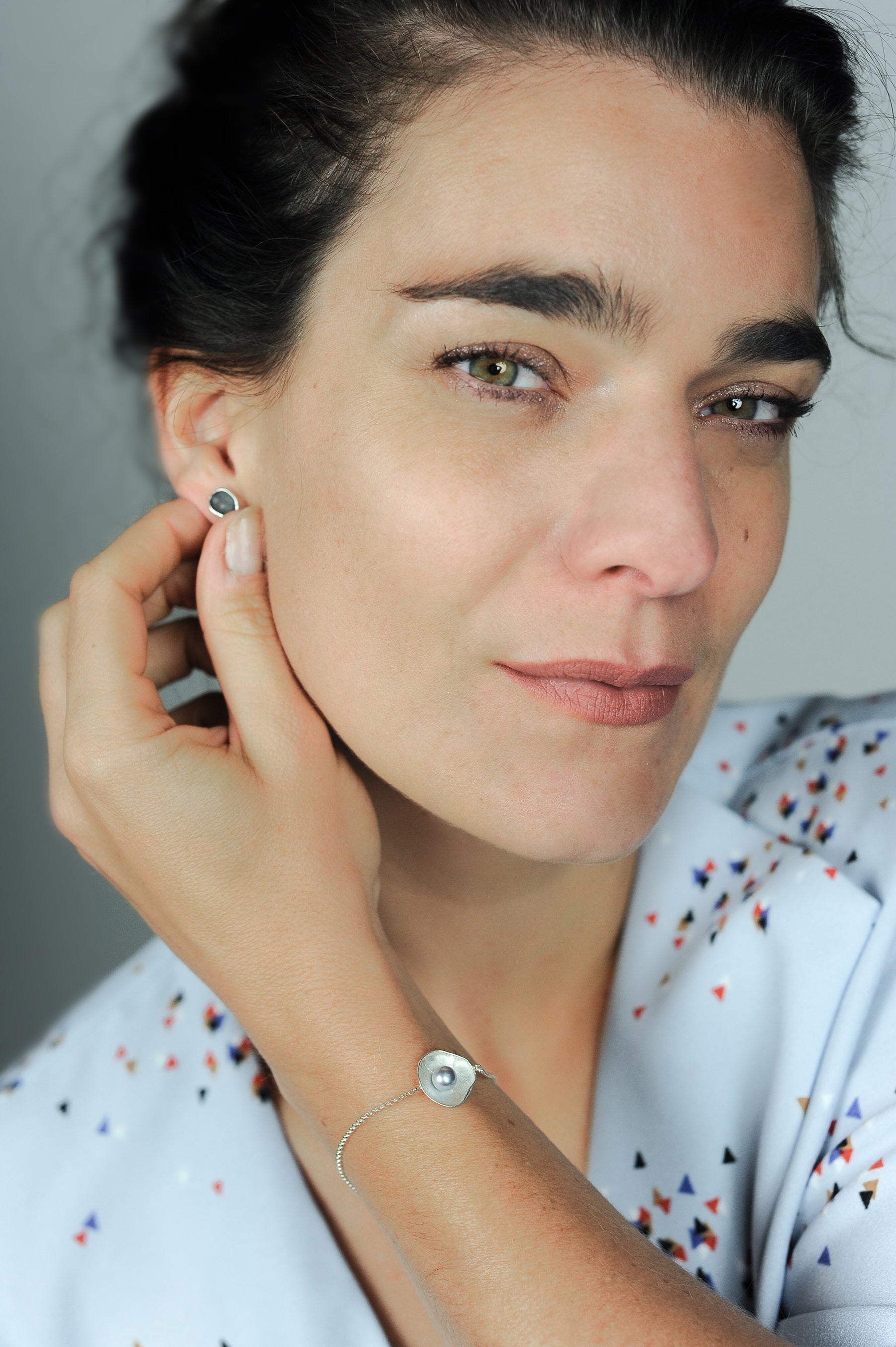 Handgemaakte oorstekers van zilver, ontworpen en gemaakt door Lianne de Witte in haar atelier in Goes gefotografeerd op model.