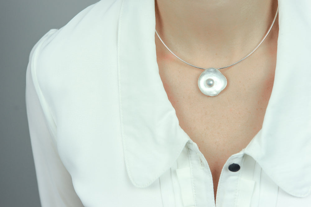 Handgemaakte hanger van zilver met parel, ontworpen en gemaakt door Lianne de Witte in haar atelier in Goes, in de vorm van een kommetje.