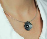 Close up hanger van donker bewerkt zilver met parel.