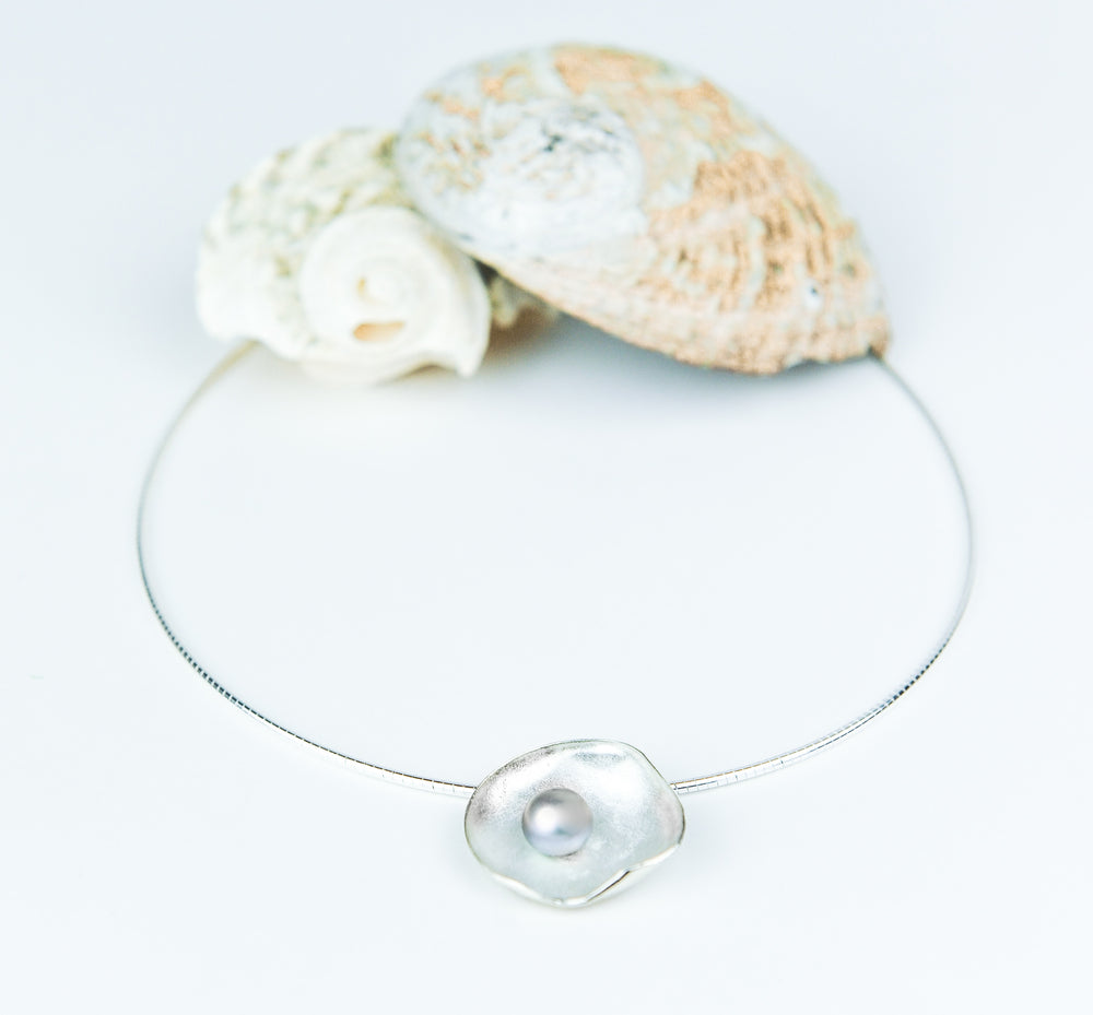 Handgemaakte hanger van zilver met parel, ontworpen en gemaakt door Lianne de Witte in haar atelier in Goes geïnspireerd op oestervorm.