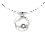 Handgemaakte zilveren hanger met grijze parel, ontworpen en gemaakt door Lianne de Witte in haar atelier in Goes, gemaakt in cirkelvorm.