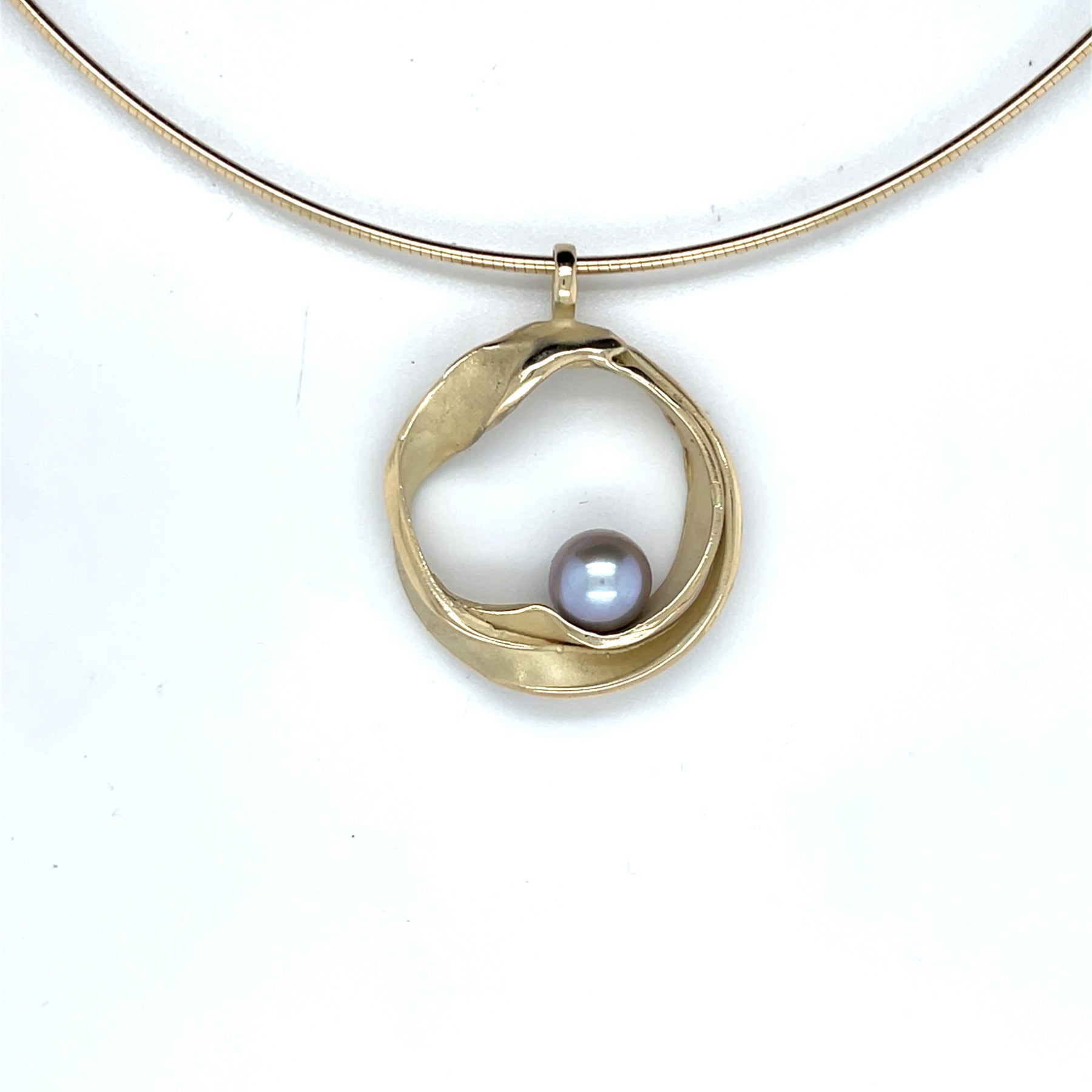 Handgemaakte geelgouden hanger met grijze parel, ontworpen en gemaakt door Lianne de Witte in haar atelier in Goes.