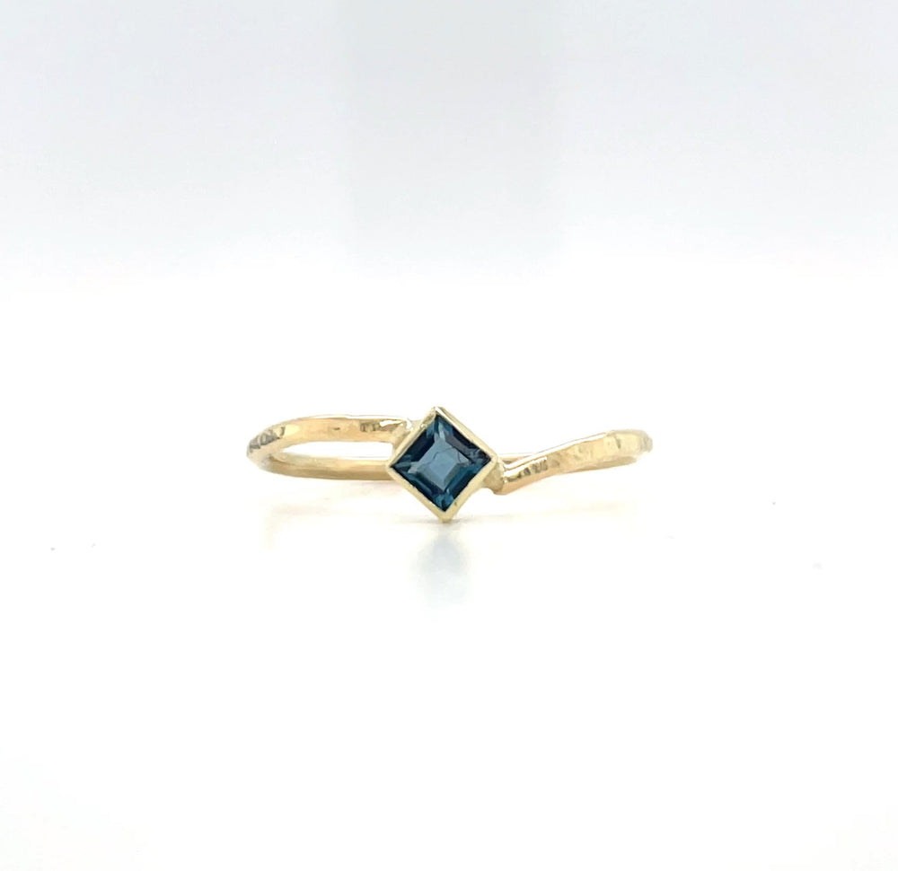 Afbeelding van een geelgouden ring, 14 karaat met petrol blauwe topaas.