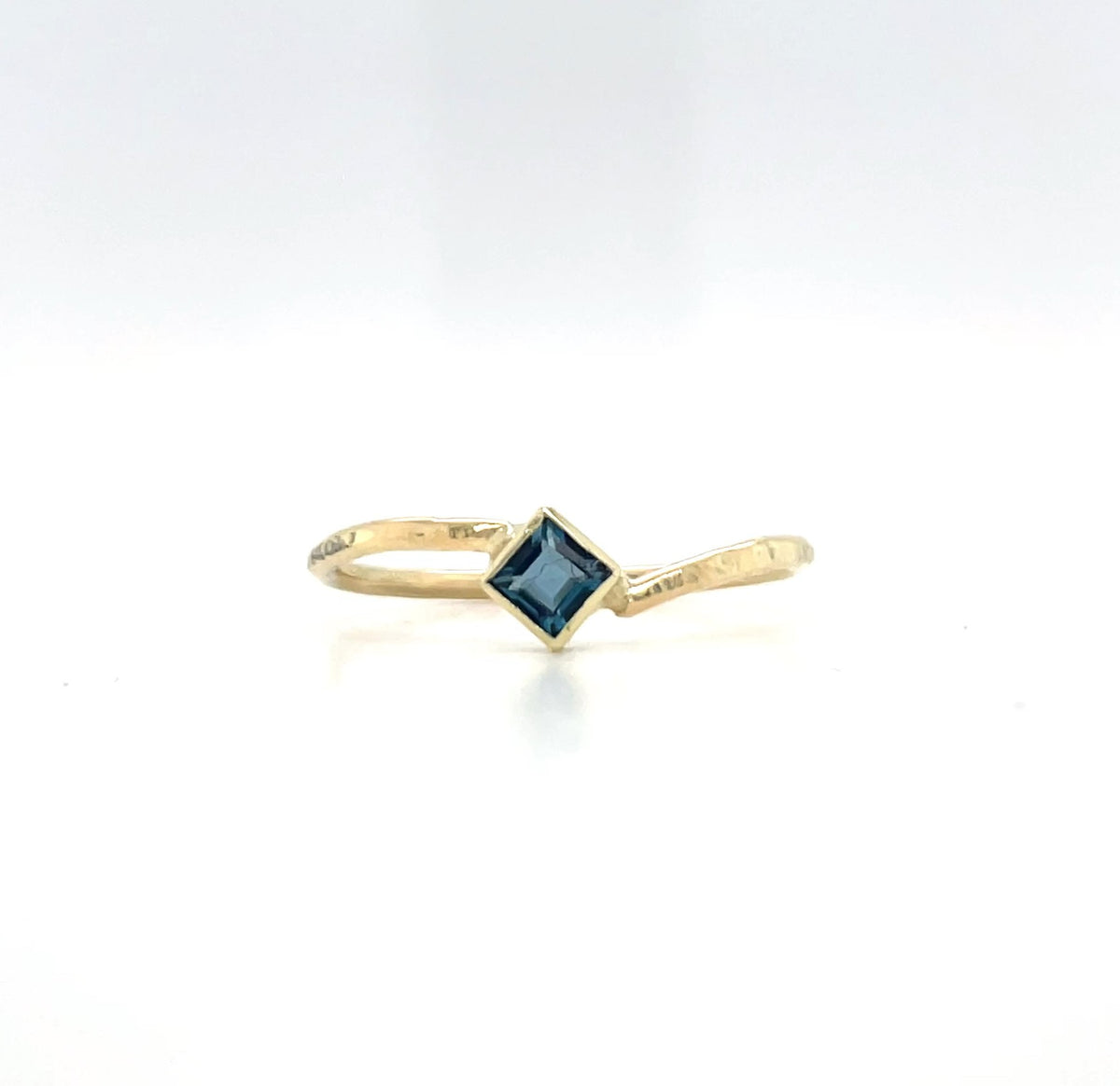 Afbeelding van een geelgouden ring, 14 karaat met petrol blauwe topaas.