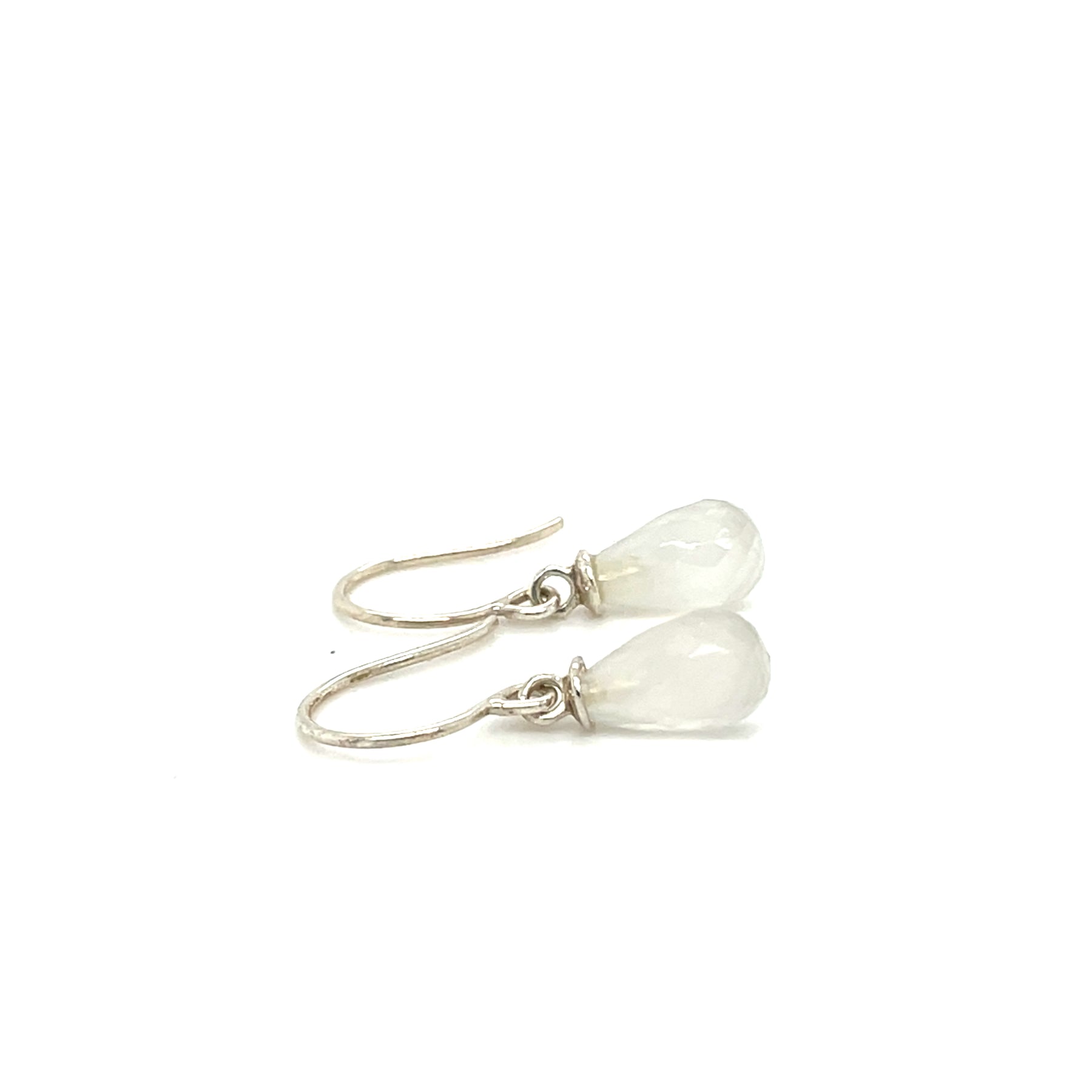 Zijaanzicht van handgemaakte oorhangers van zilver met maansteen, ontworpen en gemaakt door Lianne de Witte in haar atelier in Goes.