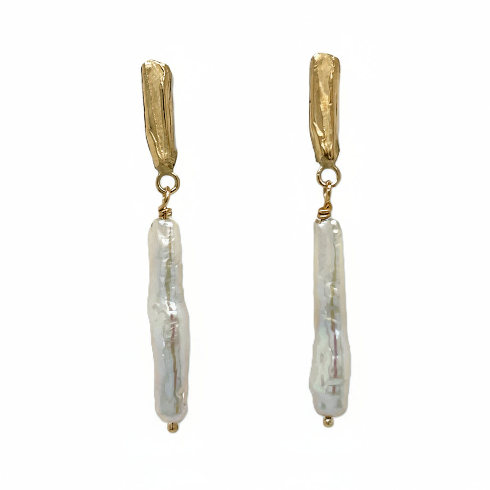 Close up van handgemaakte oorhangers van 14 karaat geelgoud met zoetwaterparel wit, ontworpen en gemaakt door Lianne de Witte in haar atelier in Goes.