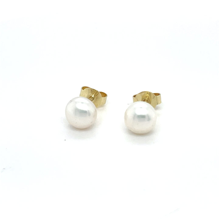 Handgemaakte oorsieraden van 14 karaat geelgoud met zoetwater parel wit, ontworpen en gemaakt door Lianne de Witte in haar atelier in Goes