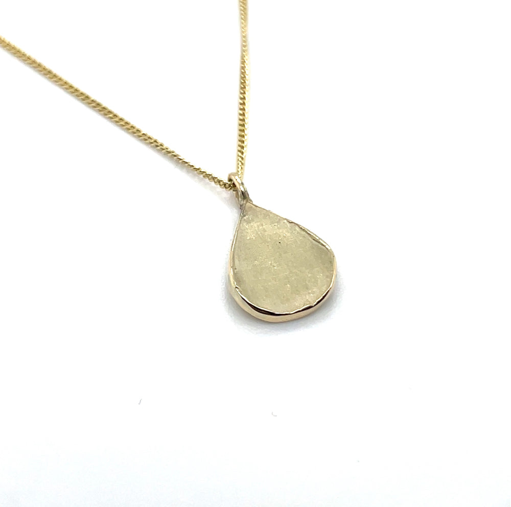 Close up van handgemaakte kleine hanger van 14 karaat geelgoud, ontworpen en gemaakt door Lianne de Witte in haar atelier in Goes