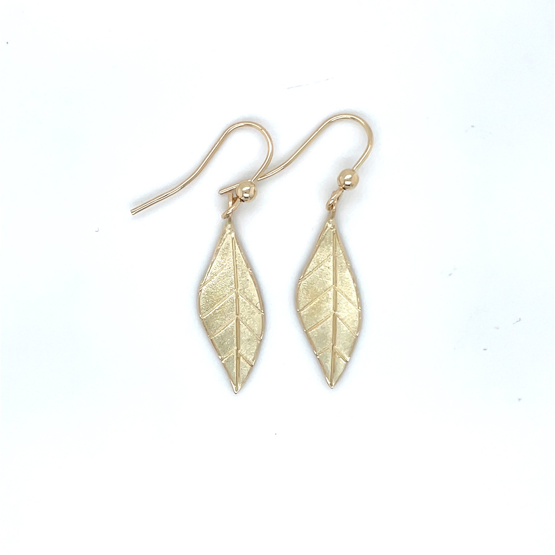 Handgemaakte oorhangers van 14 karaat geelgoud, ontworpen en gemaakt door Lianne de Witte in haar atelier in Goes in de vorm van een blad.