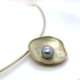 Zijaanzicht hanger geelgoud in vorm van een schelp.