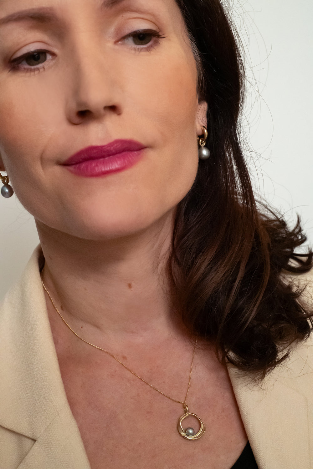 Handgemaakte gouden hanger met grijze parel, ontworpen en gemaakt door Lianne de Witte in haar atelier in Goes in cirkelvorm.