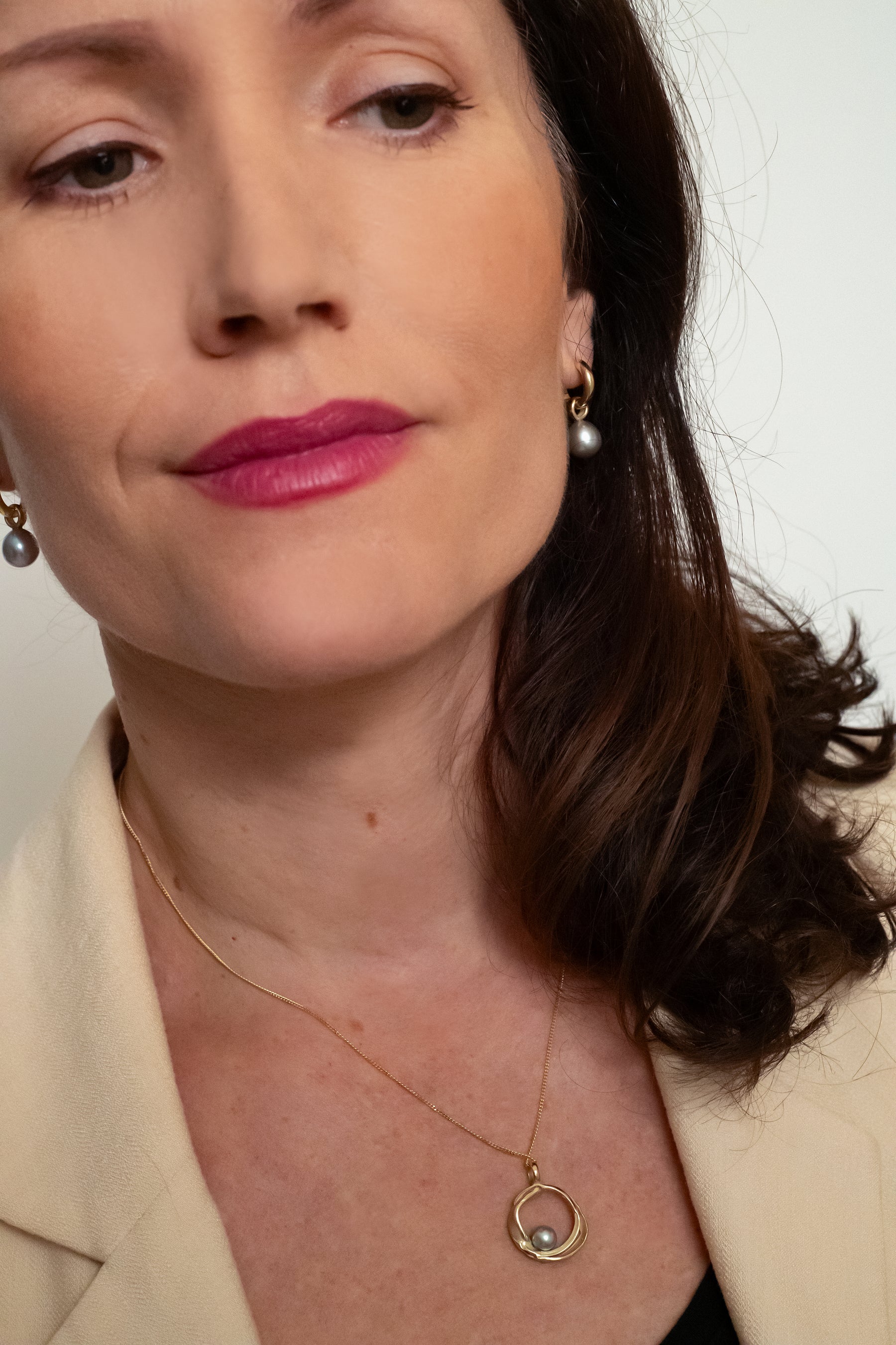 Handgemaakte gouden hanger met grijze parel, ontworpen en gemaakt door Lianne de Witte in haar atelier in Goes in cirkelvorm.