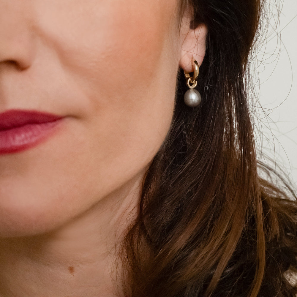 Handgemaakt oorsieraden van goud met een grijze parel, ontworpen en gemaakt door Lianne de Witte in haar atelier in Goes