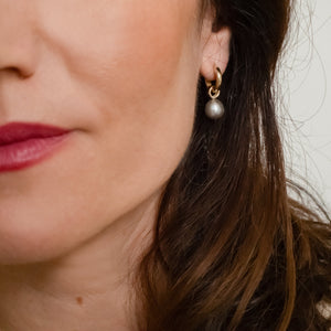 Handgemaakt oorsieraden van goud met een grijze parel, ontworpen en gemaakt door Lianne de Witte in haar atelier in Goes