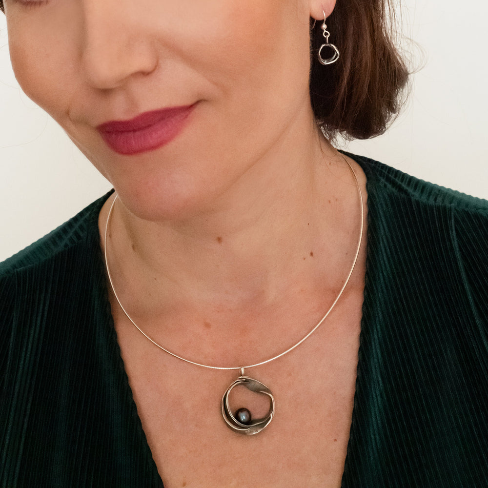 Handgemaakte hanger van zilver, ontworpen en gemaakt door Lianne de Witte in haar atelier in Goes, gefotografeerd op model.