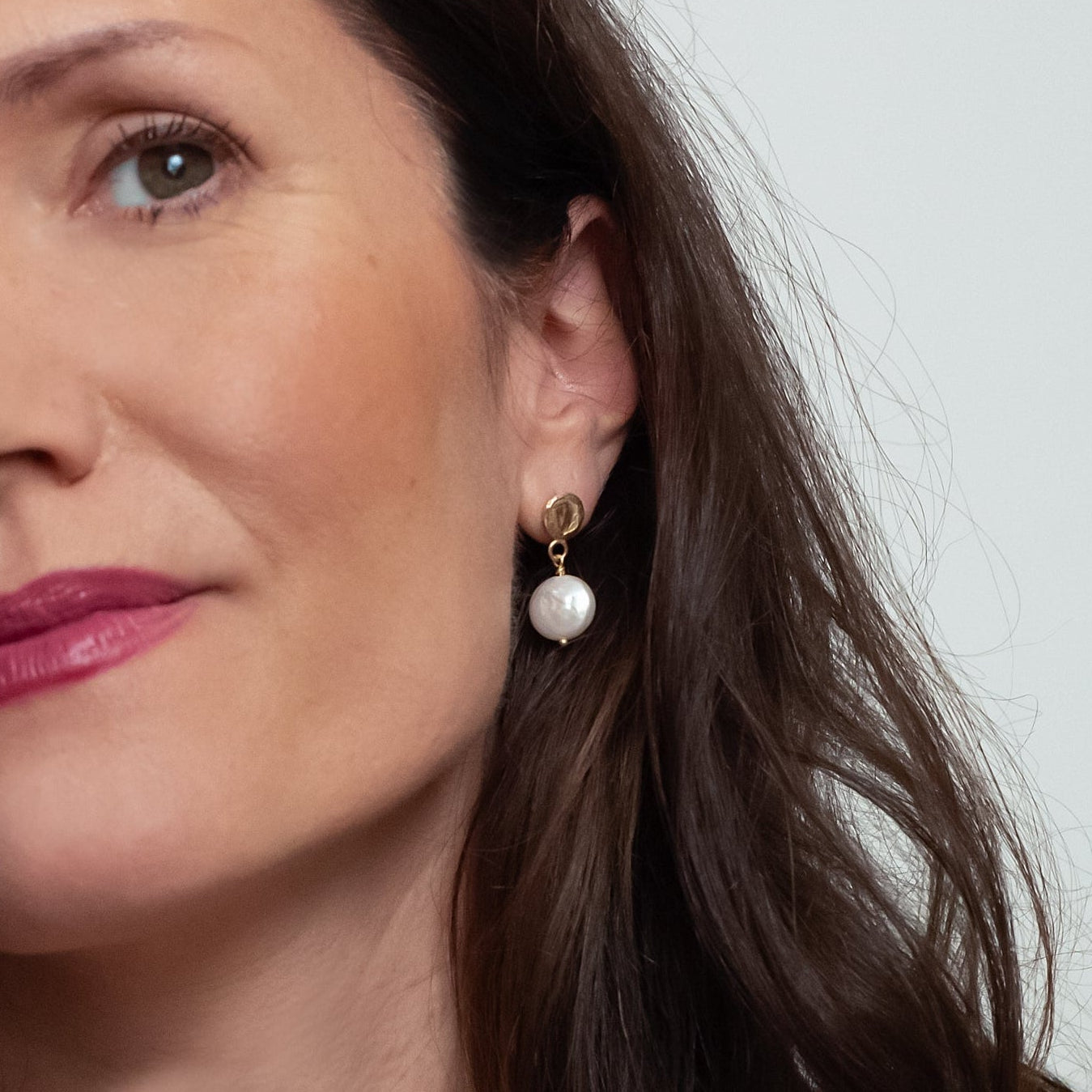 Handgemaakte oorhangers van 14 karaat geelgoud met zoetwaterparel wit, ontworpen en gemaakt door Lianne de Witte in haar atelier in Goes.