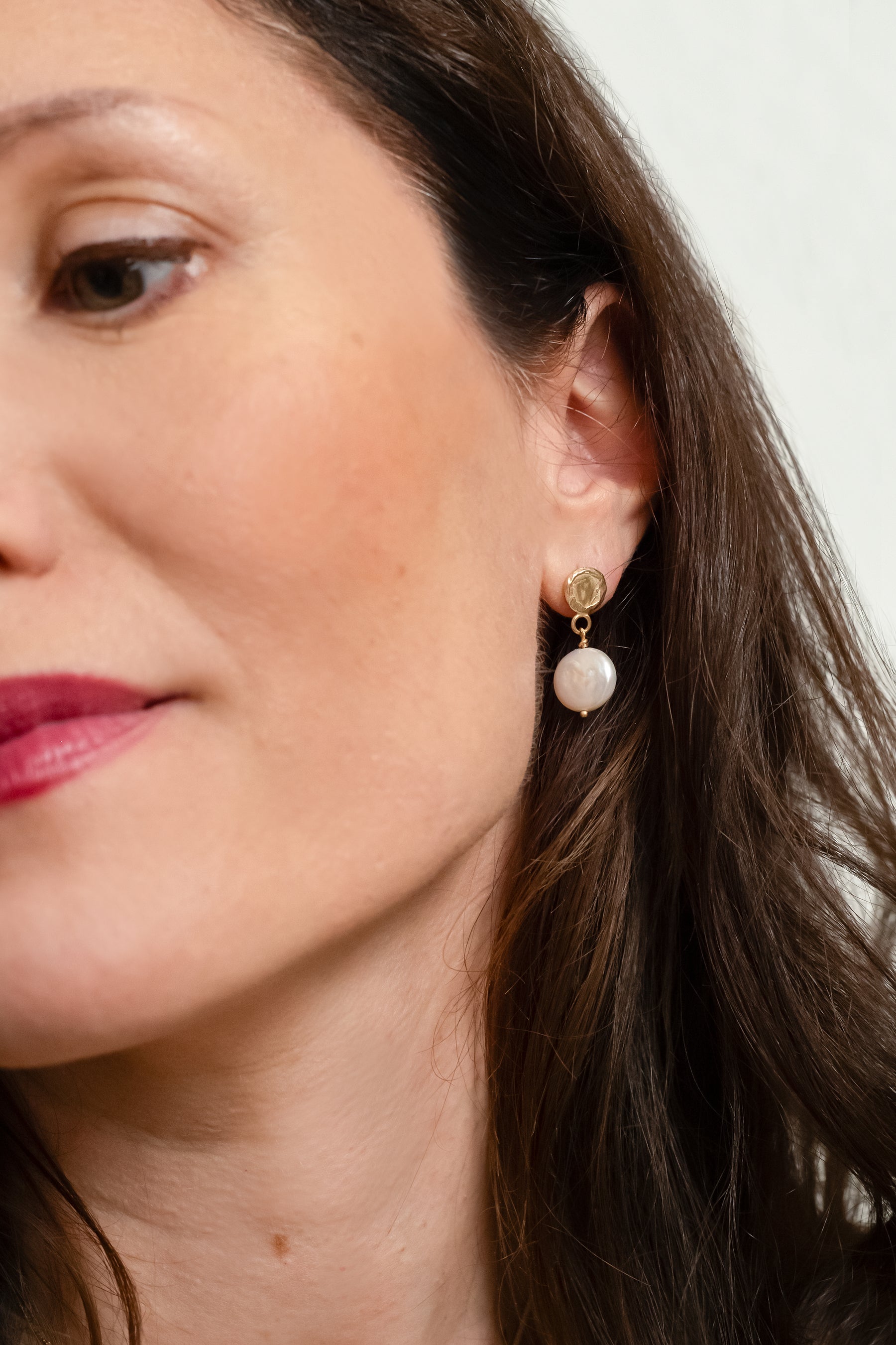 Geelgouden oorhangers met witte parel.