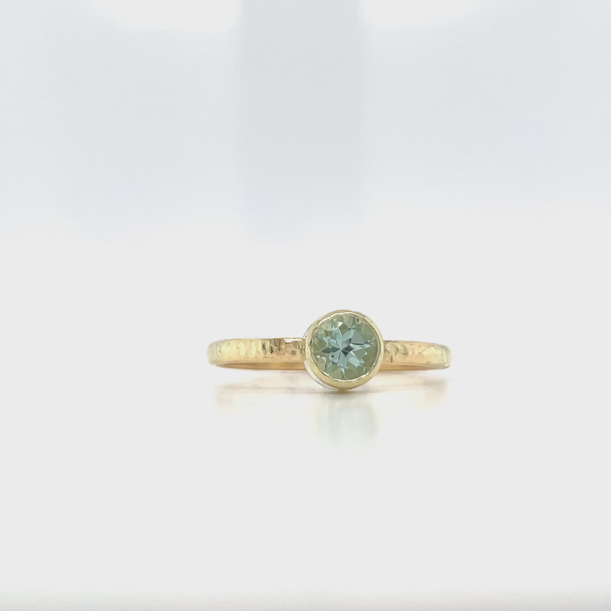 Video van geelgouden ring met hamerslag en groene toermalijn.