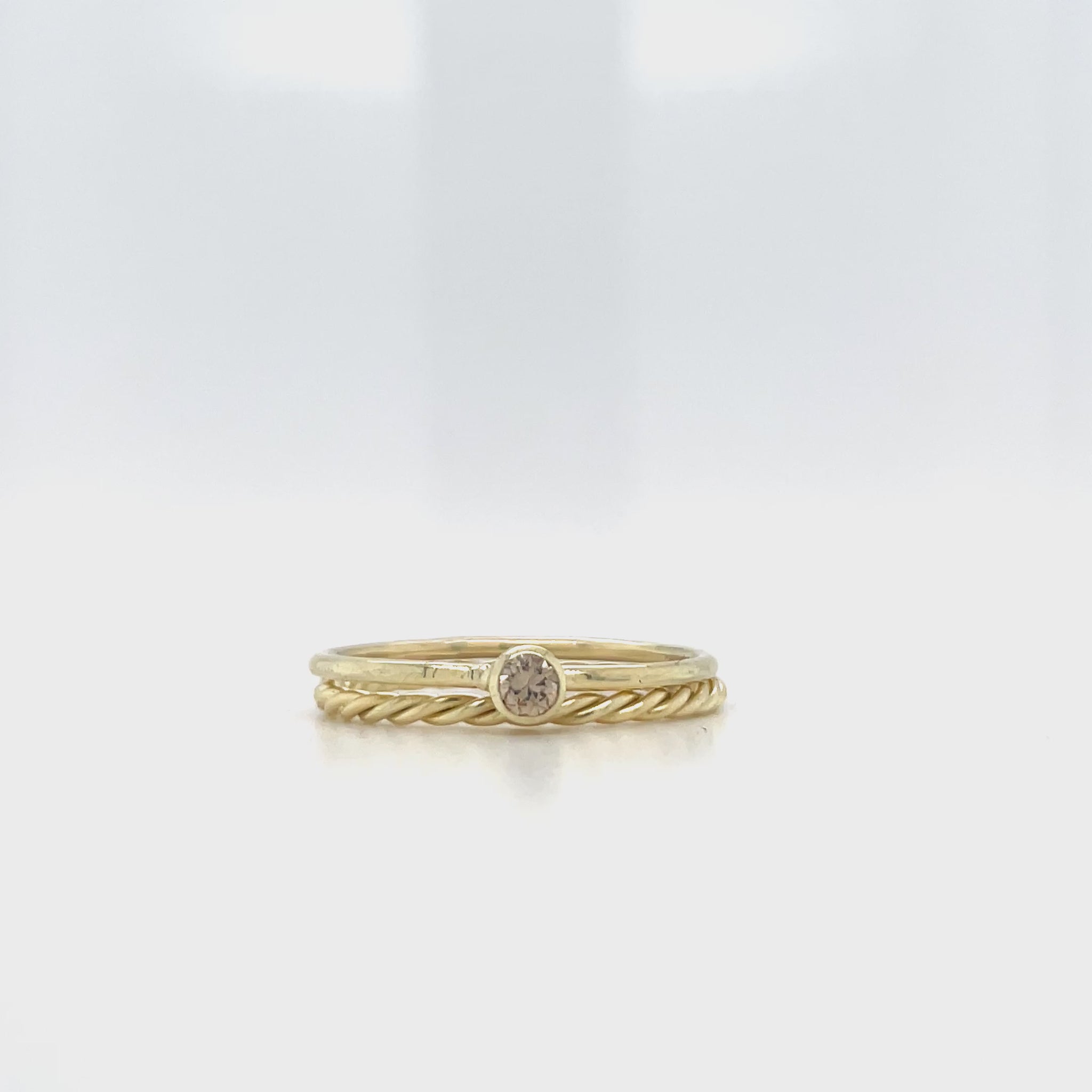 Geelgouden ring met bruine diamant en een aanschuifring met torsdraad.
